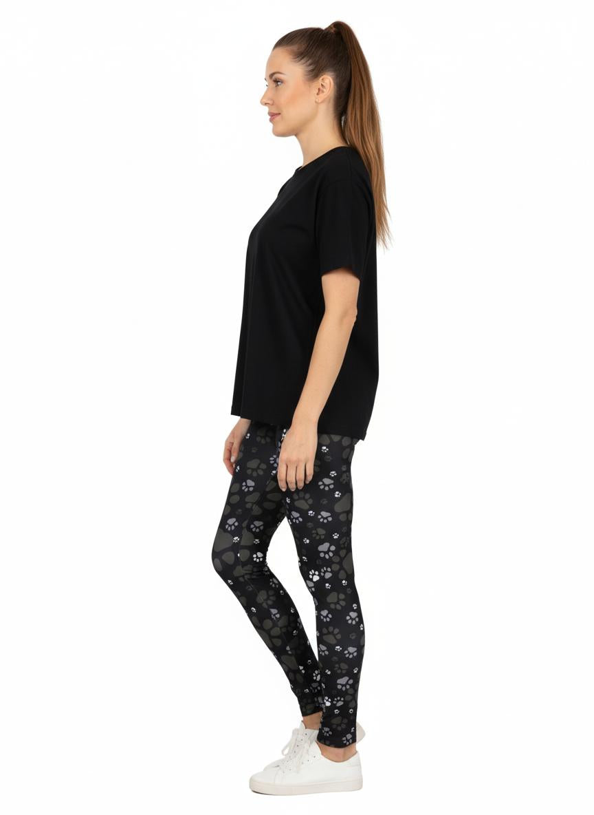 Woman wearing black paw print leggings and a black t-shirt on a white background