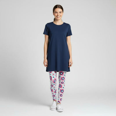 Woman wearing a navy blue tunic and daisy patterned leggings on a white background