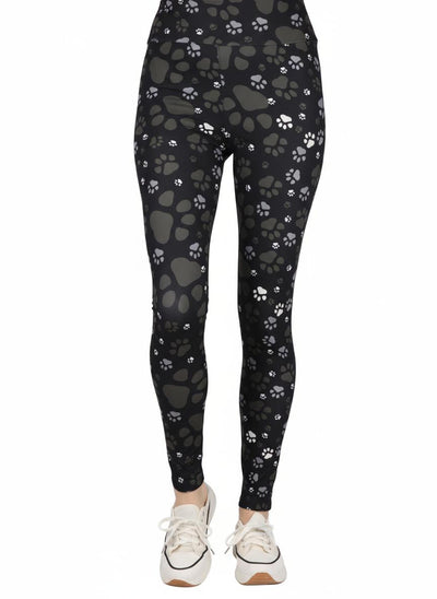 Black leggings with paw print pattern worn by a person on a white background