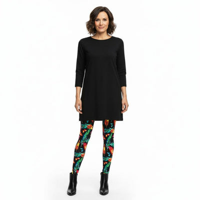 Woman wearing a black dress and colourful feather leggings on a white background