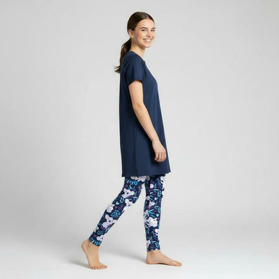 Woman wearing a navy blue top and koala leggings on a white background